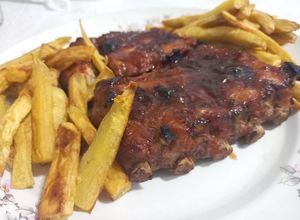 Una foto de Ribs a la barbacoa con batatas fritas