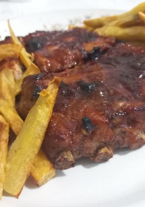 Una foto de Ribs a la barbacoa con batatas fritas