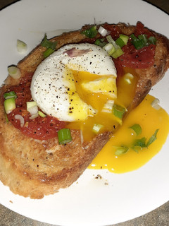 A picture of Tomato and poached egg garlic toast.