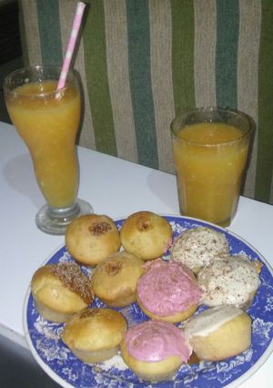 Una foto de Mufinns de colores. Y jugo de pomelo y naranja
