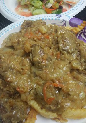 A picture of Smothered Chicken Liver over French Fries.