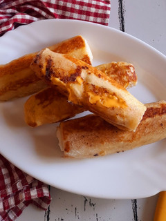 A picture of Rotolini di pane tramezzino farciti con fettine di formaggio cheddar.