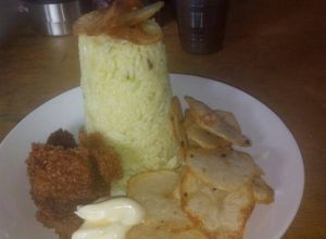Una foto de Timbal de arroz con azafrán, crutones y papas tipo chip