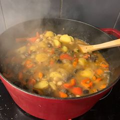 A picture of Spanish stew with chorizo and morcilla.