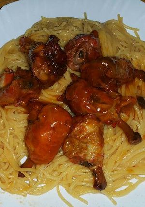 A picture of Chicken wings served with spaghetti.