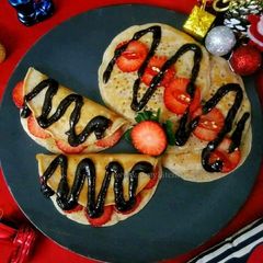 A picture of Strawberry pancakes with chocolate strawberry chilli sauce.