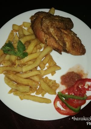 A picture of French fries with deep fried hot & tangy chicken.