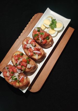 A picture of FRENCH GARLIC TOAST with TOMATO SALAD paired with BOILED EGGS..