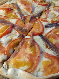 Una foto de Coca de anchoas, emmental y tomate