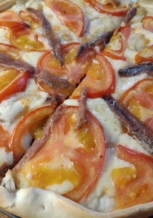 Una foto de Coca de anchoas, emmental y tomate
