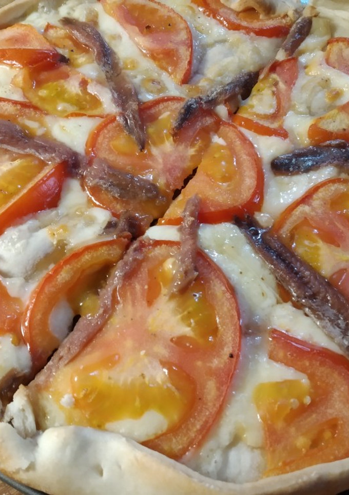 Una foto de Coca de anchoas, emmental y tomate
