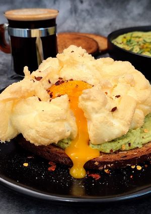 Una foto de Tostada con huevo nube y hummus de cilantro