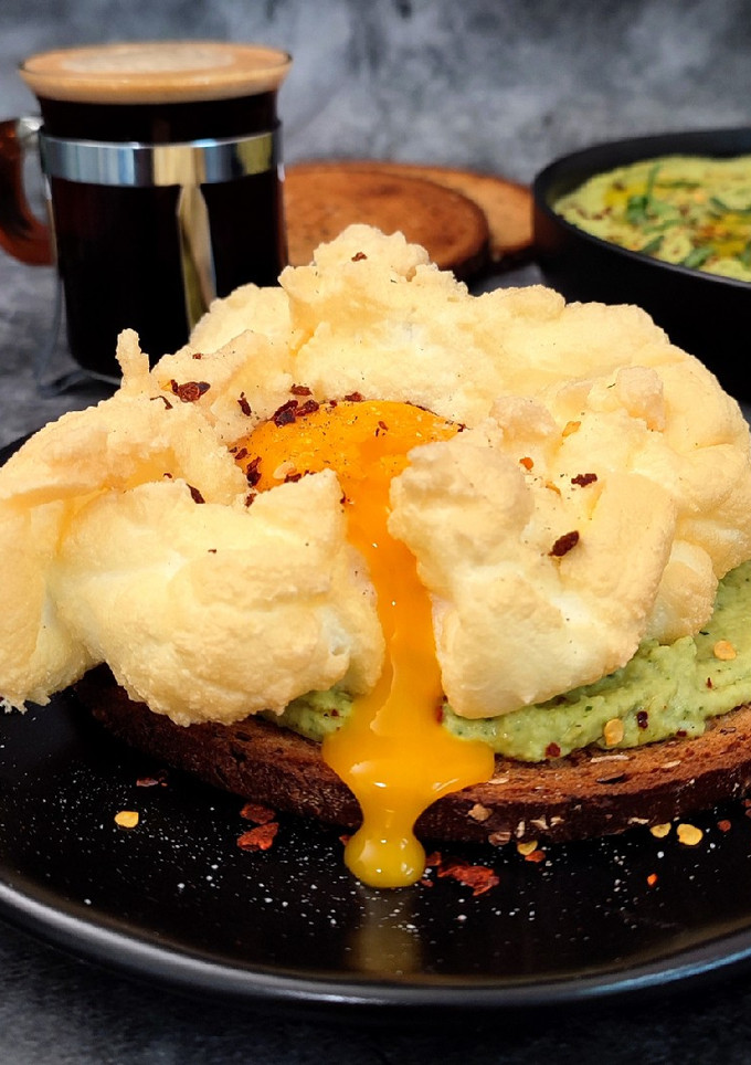 Una foto de Tostada con huevo nube y hummus de cilantro