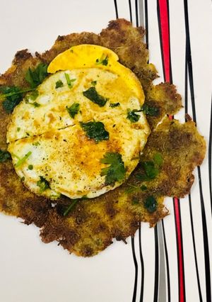 A picture of Potatoes hash browns with fried egg.