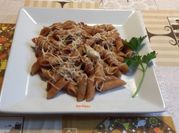 Una foto de penne con tomate y queso rallado