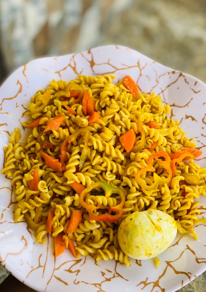 A picture of Macaroni jollof with carrots and egg.