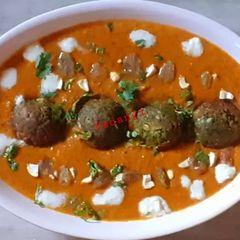 A picture of Chickpea and spinach balls in makhni gravy.