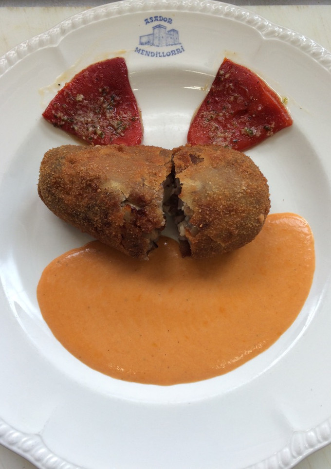 Una foto de Paticas de cerdo rellenas de lechezuelas con salsa piquillo