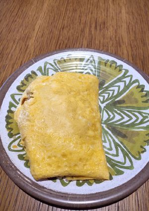 A picture of Fried Rice covered with Egg.