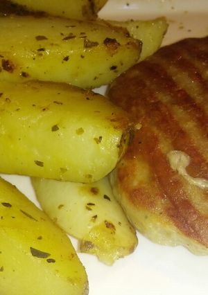Una foto de Hamburguesa de pollo con papas rústicas por $50