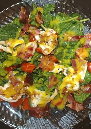 Una foto de Ensalada de espinacas,cherry,brie,beicon, cebolla crujiente y mostaza-miel