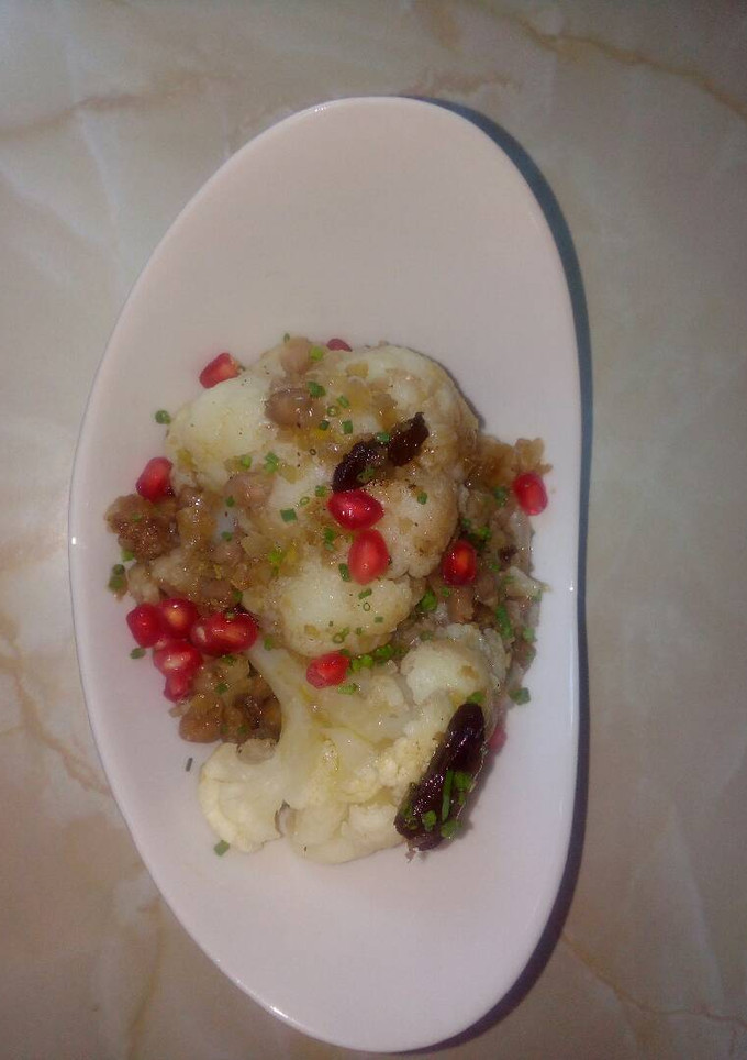 Una foto de Coliflor con granada y ajo negro al aceite de ajo negro