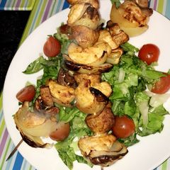 A picture of Healthy chicken skewers served with a salad.