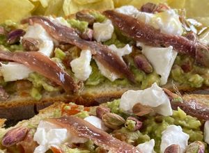 Foto principal de Tosta de Burrata de Cabra con Aguacate, Anchoas, Pistachos y Miel 🍯
