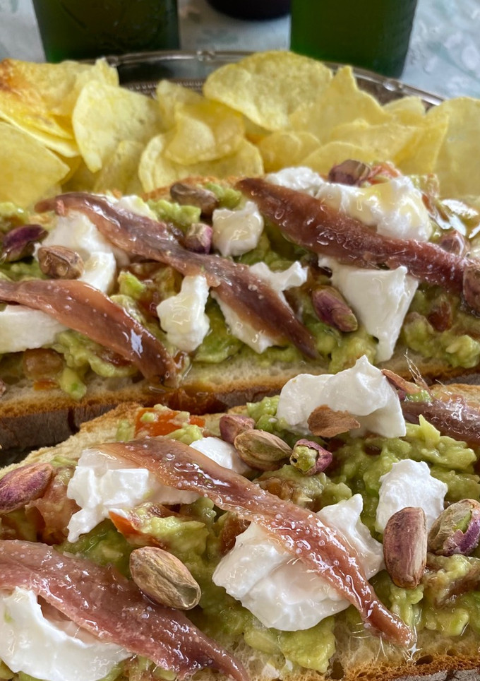 Una foto de Tosta de Burrata de Cabra con Aguacate, Anchoas, Pistachos y Miel 🍯