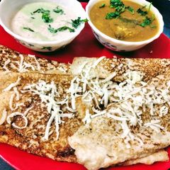 A picture of Cheese Dosa with coconut chutney and sambar.