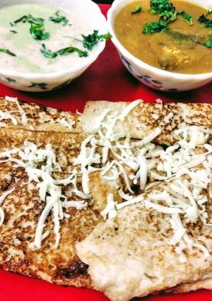 A picture of Cheese Dosa with coconut chutney and sambar.