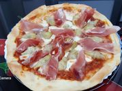 Una foto de alcachofa con jamón y salsa