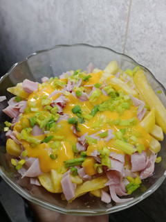 Una foto de 🍟Papas fritas, con queso cheddar, jamón cocido y cebolla de verdeo