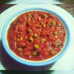 A picture of Tomato chutney with peas.