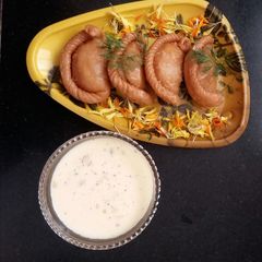 A picture of #Holi -Gujia filled with Cashew, dipped in Syrup.