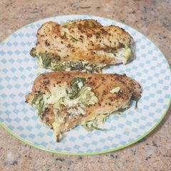 A picture of Baked chicken with cheesy spinach stuffing.