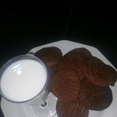A picture of Chocolate cookies with a cup of milk.