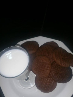 A picture of Chocolate cookies with a cup of milk.
