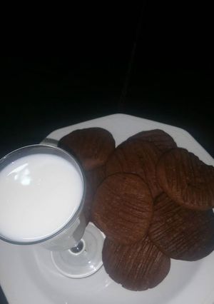 A picture of Chocolate cookies with a cup of milk.