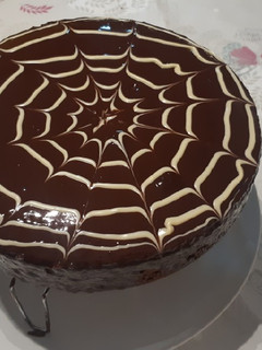 Una foto de Bizcocho de chocolate con cobertura y tela de araña