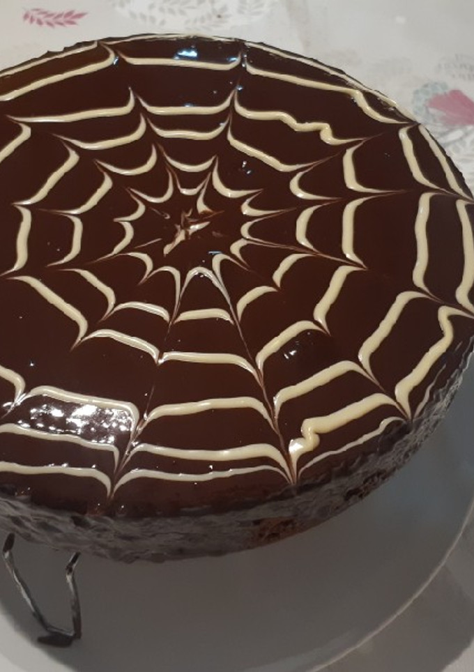 Una foto de Bizcocho de chocolate con cobertura y tela de araña