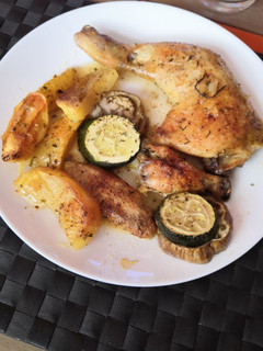 Una foto de Muslos de pollo asados con patatas, berenjena y calabacín