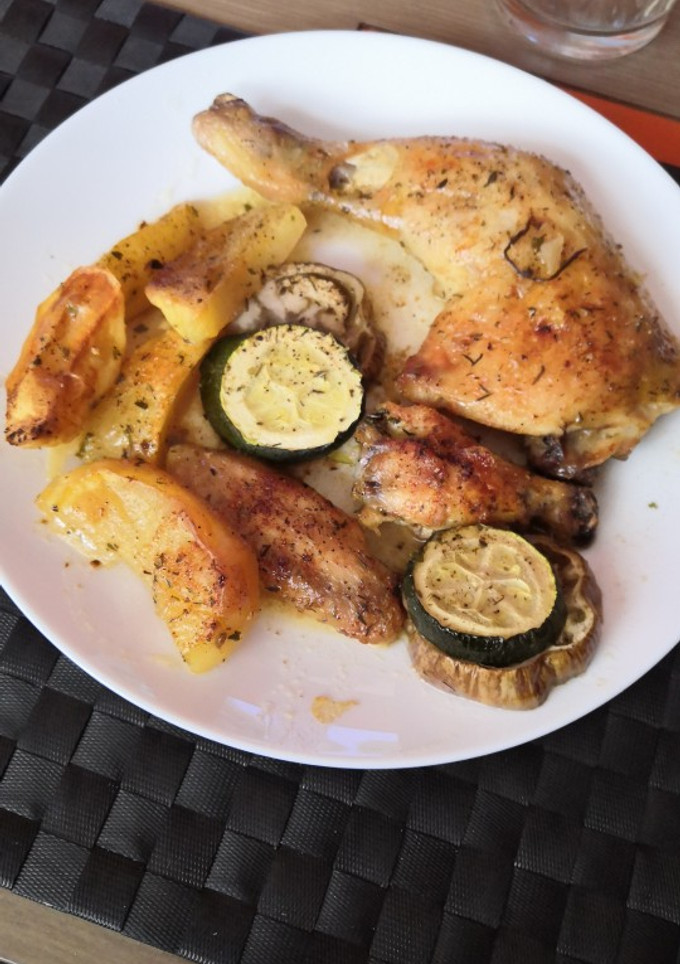 Una foto de Muslos de pollo asados con patatas, berenjena y calabacín