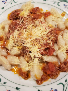 Una foto de Ñoquis de papa con bolognesa y crema