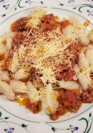 Una foto de Ñoquis de papa con bolognesa y crema