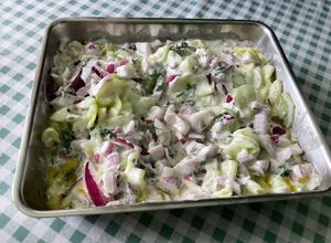 Une photo de Salade de concombre mariné à la crème, persil et oignon rouge