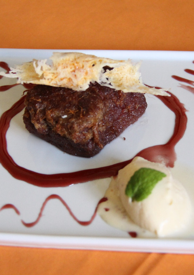 Una foto de Torrija de brioche al vino tinto con crujiente de queso y quenelle de helado de vainilla