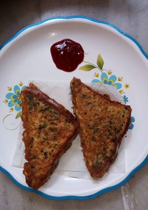 A picture of Cheesy egg sandwich with stuffing mint chutney.
