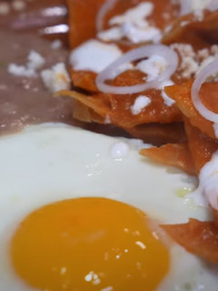 Una foto de Chilaquiles Rojos Rancheros Con Huevos Estrellados