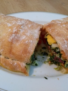 Una foto de Calzone de salami, espinacas, pimiento y mozzarella